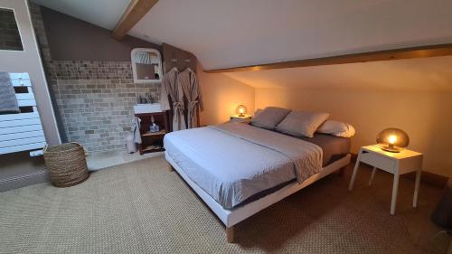 een slaapkamer met een groot bed en een bakstenen muur bij Gîte Le Caprice SPA & Sauna in Génissieux
