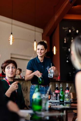 a man standing at a bar holding a drink at Hôtel Lilybloom in Le Havre