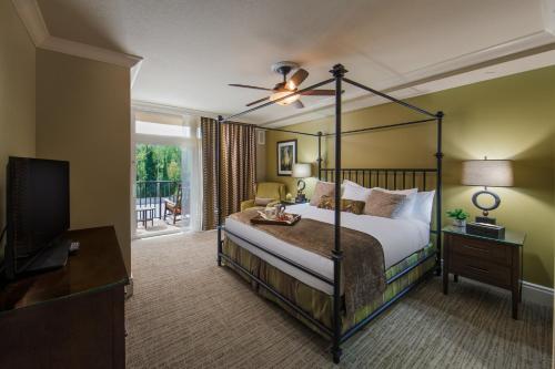 Holiday Inn Club Vacations Smoky Mountain Resort, an IHG Hotel في غاتلينبرغ: غرفة نوم بسرير مظلة وتلفزيون