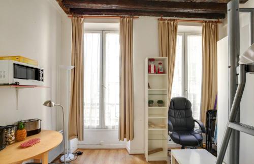 un salon avec un bureau et une chaise dans l'établissement Lavie maison - Comfortable studio near the Marais, à Paris