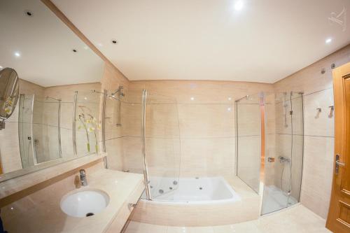 Un baño con bañera, lavabo y ducha. en Balcón del Puerto, Ático-Solarium, en Tazacorte