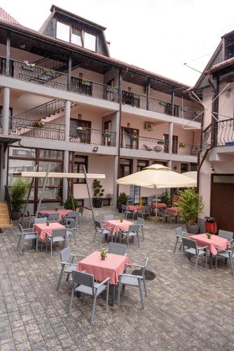 a courtyard with tables and chairs and a building at Hotel Stefani in Sibiu