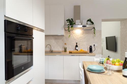 une cuisine avec des placards blancs et un comptoir dans l'établissement Modern Stone Apartment in the Heart of Bari, à Bari