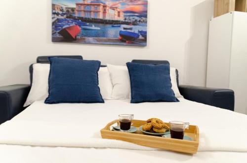 a tray of food on a bed with two glasses of coffee at Modern Stone Apartment in the Heart of Bari in Bari