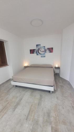 a bedroom with a bed in a white room at Luciae Domus in Roccascalegna