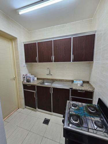 uma cozinha com um lavatório e um fogão em استراحة المسافر em Al Ain