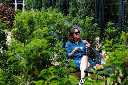 a woman sitting on a chair eating food at Hôtel Lilybloom in Le Havre