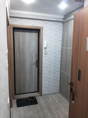 La salle de bains est pourvue d'une douche avec une porte et des chaussures. dans l'établissement Ауэзова, à Petropavlovsk-Kamtchatski