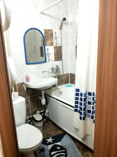 a bathroom with a toilet and a sink and a tub at Ауэзова in Petropavlovsk