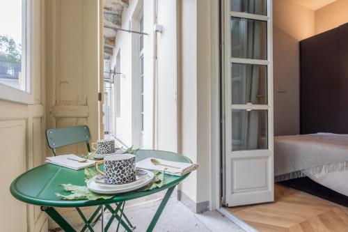 uma mesa verde com um copo e pratos em Lagrange Design Apartments by Wonderful Italy em Turim