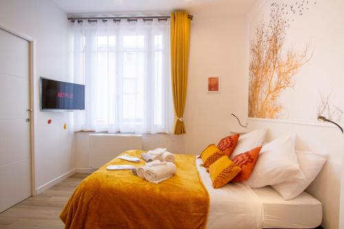 - une chambre avec un lit et une couverture jaune dans l'établissement Promenade d'Automne - Netflix & Wifi - Parking Gratuit - check-in 24H24 - GoodMarning, à Châlons-en-Champagne