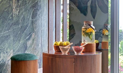 a wooden table with bowls of fruit and a vase at Terme Europa in Abano Terme