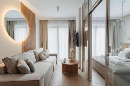 a living room with a couch and a bed at Muse - LoftAffair Spa Collection in Kraków