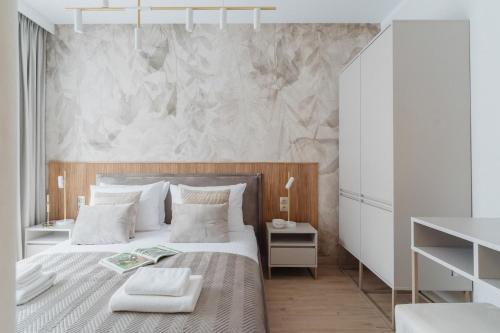 a bedroom with a large bed with white walls at Muse - LoftAffair Spa Collection in Kraków