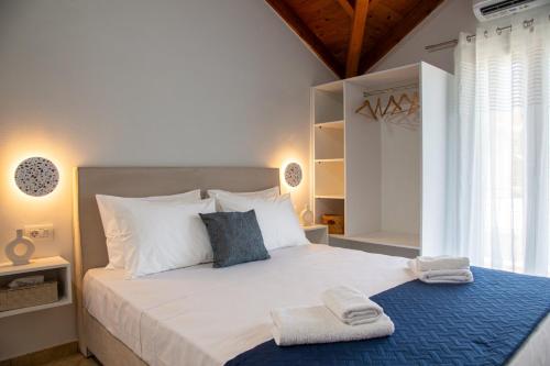 una camera da letto con un grande letto bianco con asciugamani di Your Destination a Lixouri