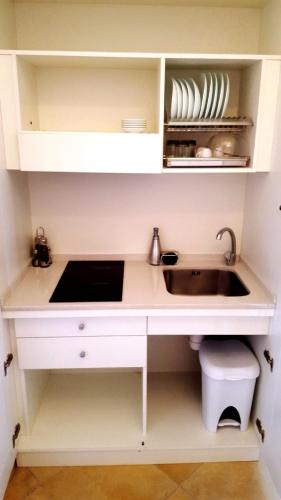 a kitchen with white cabinets and a sink and a counter at Palazzo Zimatore Residenza D'Epoca in Pizzo
