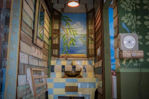a bathroom with a sink and a painting on the wall at Phranakorn-Nornlen in Bangkok