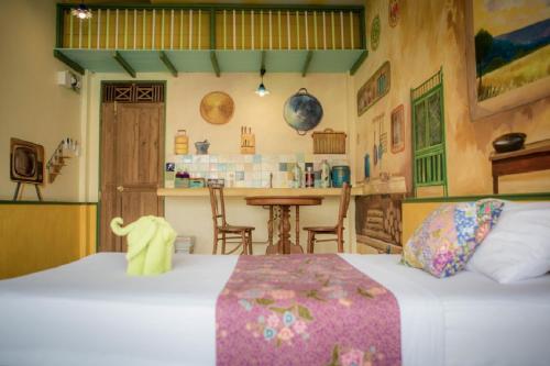 a bedroom with two beds and a table and a kitchen at Phranakorn-Nornlen in Bangkok