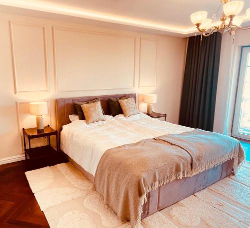 una camera da letto con un grande letto con due comodini di Casa das Rosas a Carvoeira