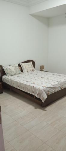 a bed in a room with a white wall at One bedroom apartment with sea view in Sousse