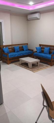 a living room with blue couches and a table at One bedroom apartment with sea view in Sousse