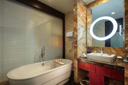a bathroom with a bath tub and a sink at Hilton Beijing Capital Airport in Shunyi
