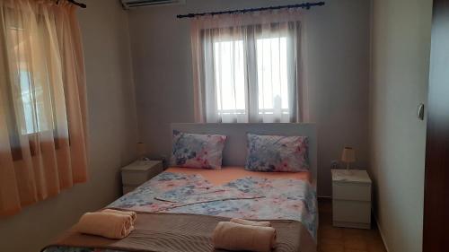 a small bedroom with a bed and a window at Villa Despina in Nea Iraklia