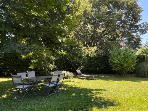 a picnic table and chairs in the grass at VILLA BONVOULOIR in Bagnères-de-Bigorre