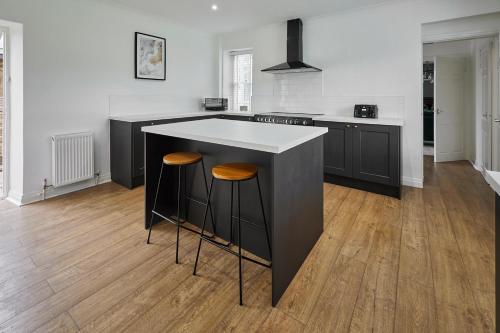 a kitchen with a island with two bar stools at Stay House - Rural Retreat in Kepwick