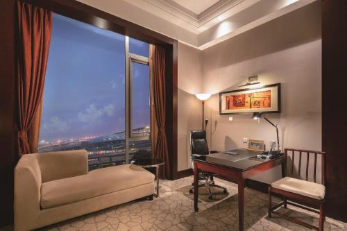 a hotel room with a desk and a chair and a window at Hilton Beijing Capital Airport in Shunyi