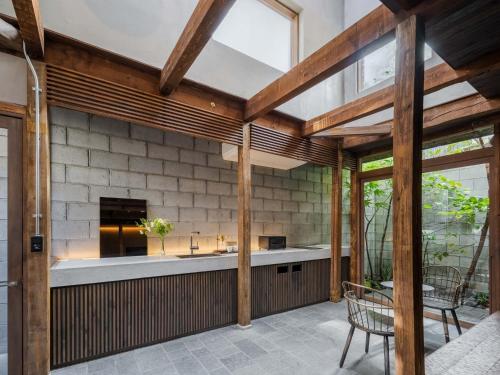 an outdoor kitchen with a fireplace and wooden beams at Yuzunoe Machiya House in Kyoto