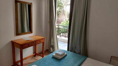 a bedroom with a bed and a mirror and a window at Amalthia Hotel Apartments in Rethymno