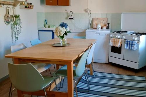 Brosso的住宿－La casa di Elma，厨房配有木桌,上面有花瓶