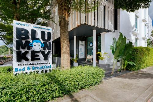 a sign in front of a building with a big key at Blu Monkey Boutique Samkong, formerly Blu Monkey Bed & Breakfast Phuket in Phuket