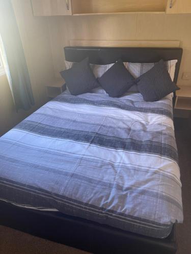 łóżko z niebiesko-białym kocem i poduszkami w obiekcie Bird Lake Pastures 53 w mieście Northampton
