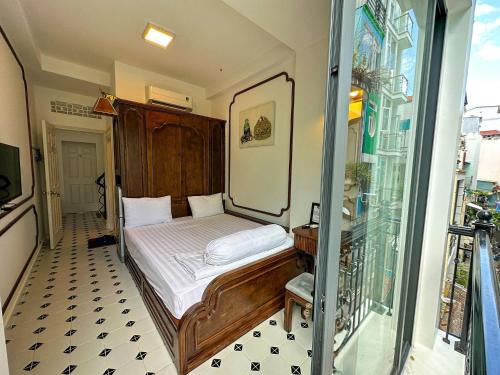 a small bedroom with a wooden bed and a window at Vika Homestay in Ho Chi Minh City