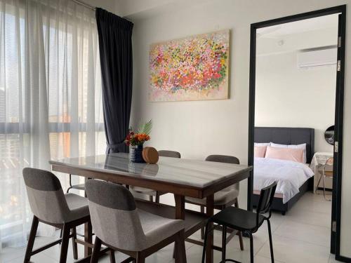 - une salle à manger avec une table, des chaises et un lit dans l'établissement Urban Suites Georgetown, Penang, à Jelutong