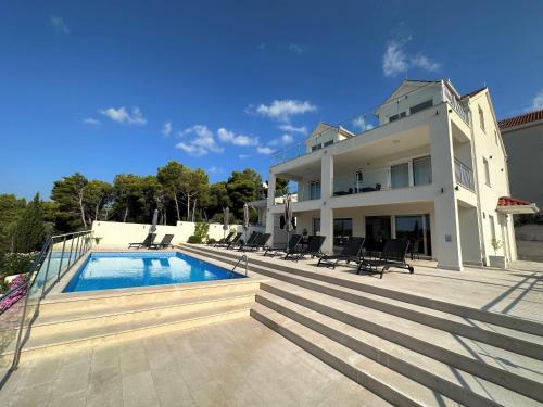 uma casa grande com uma piscina em frente em Villa Lovisa, private pool and amazing sea view em Milna