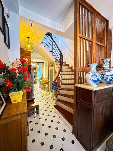 a living room with a staircase and vases on a table at Vika Homestay in Ho Chi Minh City