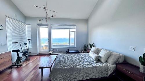 a bedroom with a bed and a large window at Oceanview Property in West Vancouver
