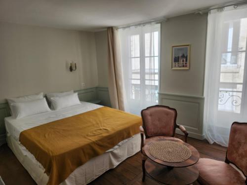 1 dormitorio con 1 cama grande y 2 sillas en LE ZOLA, en Bourges