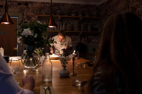 een man aan een tafel in een keuken bij Åsundsholm Golf & Country Club in Vegby