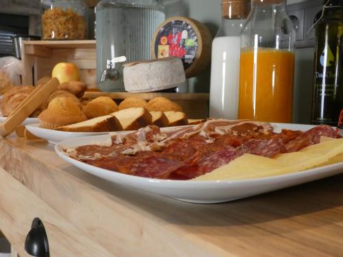 a plate of food on a table with bread and meat at LA ALCOBA DE SAYAGO in Bermillo de Sayago