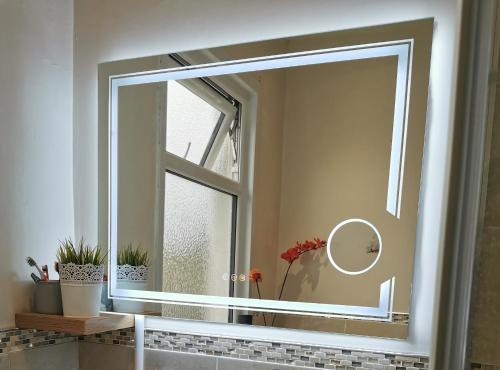 Large Double Room with Private Toilet and Shower في ساوثيند أون سي: مرآة في الحمام مع نافذة