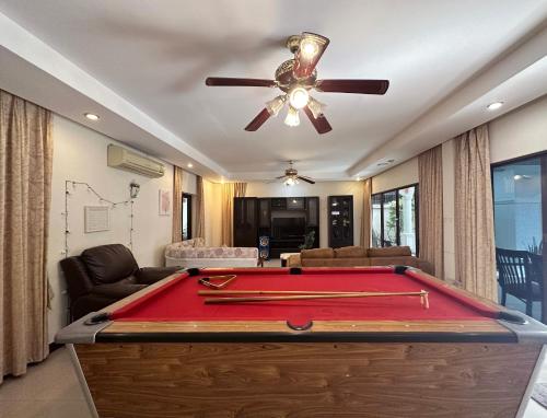 a room with a pool table and a ceiling fan at Blooming Hill Boutique Suites in Pattaya South