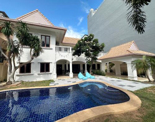 a house with a swimming pool in front of a house at Blooming Hill Boutique Suites in Pattaya South