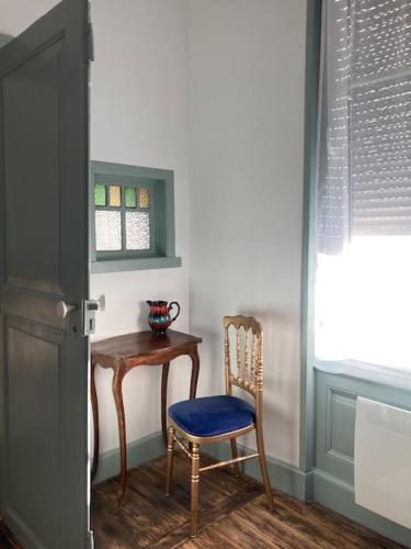a room with a table and a chair next to a door at CHACHACHA appartement de charme, calme,balcon 5pers 4étoiles, patio in Mulhouse