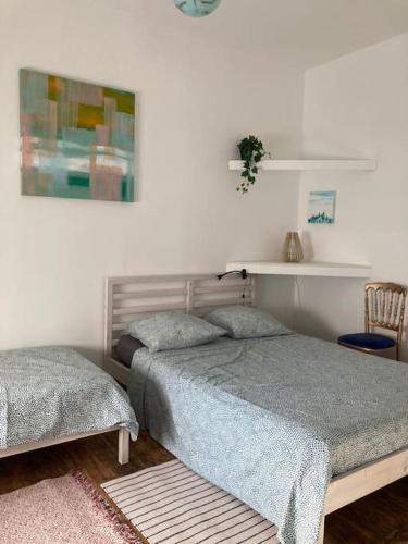 - une chambre avec 2 lits et une photo sur le mur dans l'établissement CHACHACHA appartement de charme calme balcon, à Mulhouse