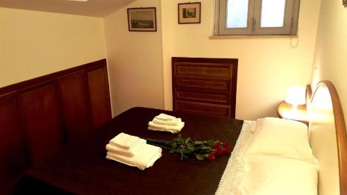 a bedroom with a bed with towels and flowers on it at Palazzo Zimatore Residenza D'Epoca in Pizzo