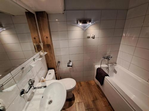 a bathroom with a toilet and a sink and a tub at ArtApartment - klimatyczny Przemyśl in Przemyśl